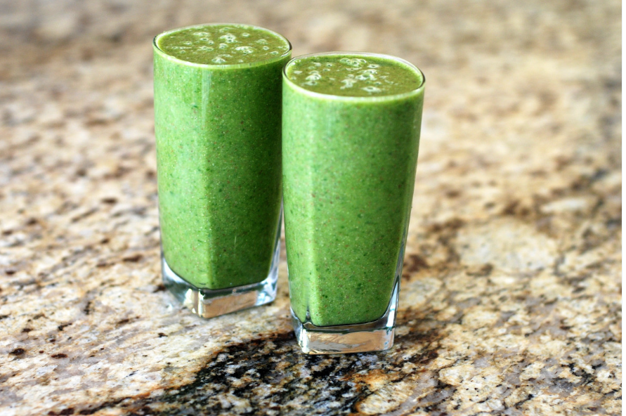 en la imagen se ven dos vasos de una bebida proteíca de color verde encima de una encimera